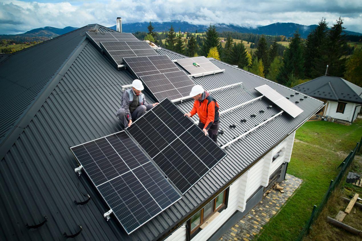 Zwei Solarteure montieren Photovoltaik-Module auf Hausdach zur späteren Nutzung mit Deye Hybrid Wechselrichter