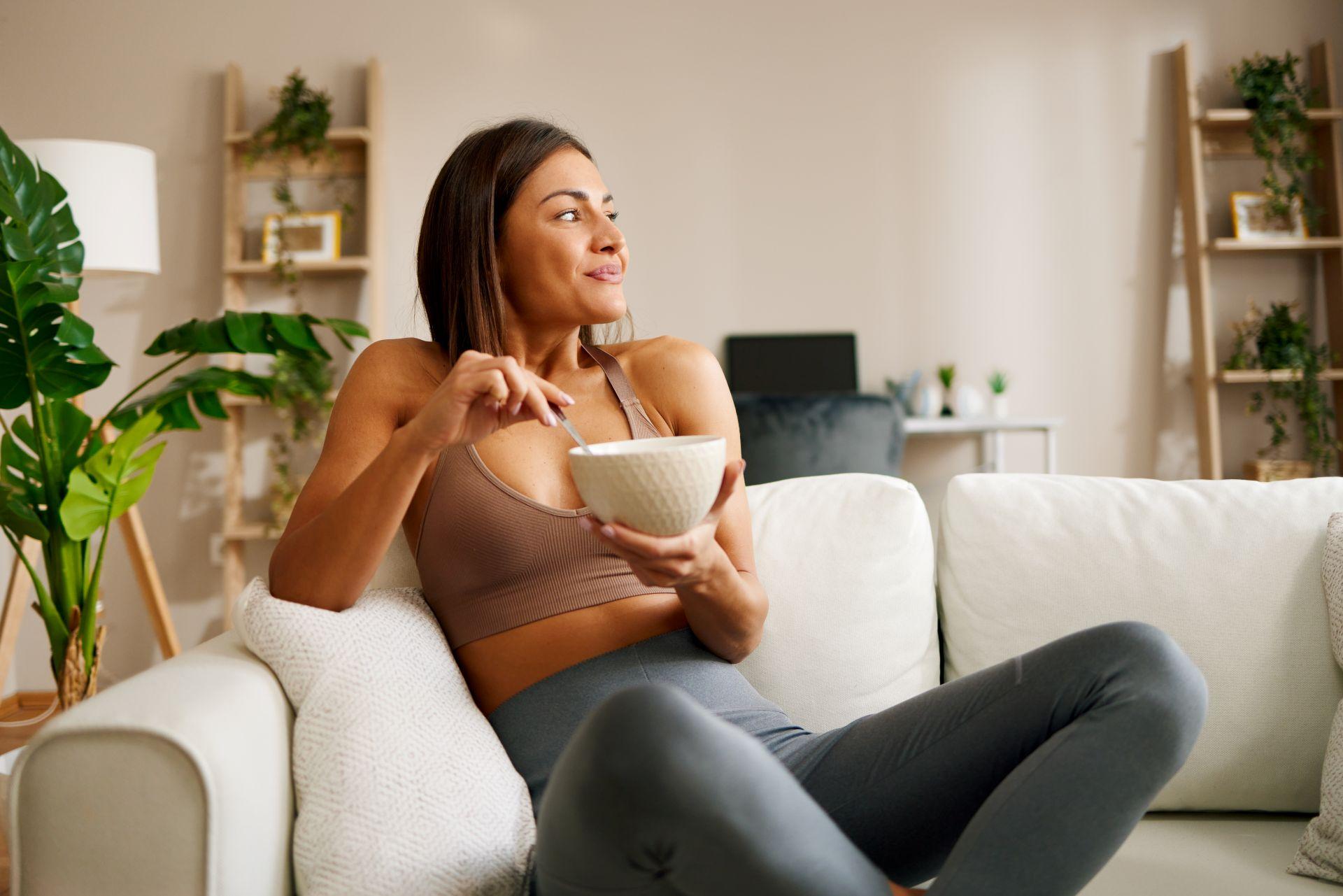 frau entspannt auf sofa mit fruehstueck nach effektiver pflegeroutine