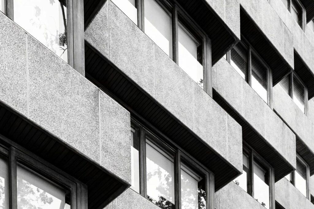 Detailaufnahme einer modernen Betonfassade mit Fenstern – steht symbolisch für technische Planung und Gebäudestruktur