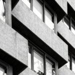 Detailaufnahme einer modernen Betonfassade mit Fenstern – steht symbolisch für technische Planung und Gebäudestruktur